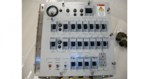 Electrical control panel with switches, indicators, and gauges.