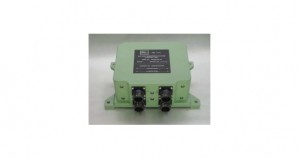 A green electronic device with connectors and a label on top.