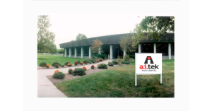 Corporate building exterior with landscaped garden and Aitek sign.