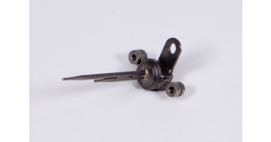 Close-up of a metal automotive part with mounting holes and a lever arm.