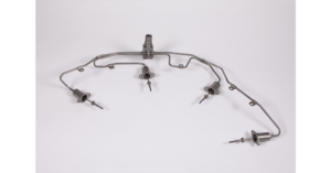 A metal fuel injector rail with attached injectors for an engine.