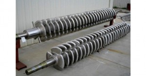Two large industrial metal rollers with helical fins.