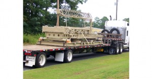 Flatbed trailer carrying large wooden crates and equipment.